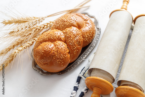 Torah scroll, prayer shawl tallit, kippah and bread. Concept of Jewish holidays Shavuot photo