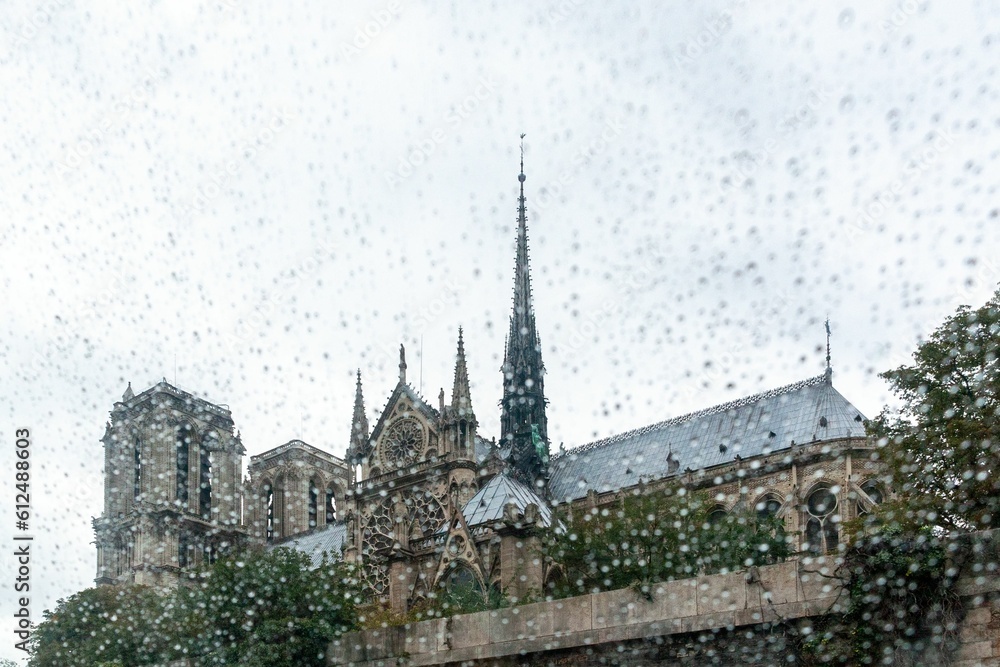 Beautiful shot of Notre-Dame de Paris Cathedral behind window covered with rain drops