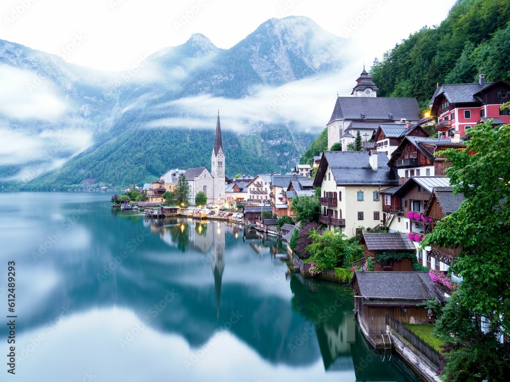 Breathtaking postcard view of buildings and Hallstatter See in Hallstatt, Austria on foggy day