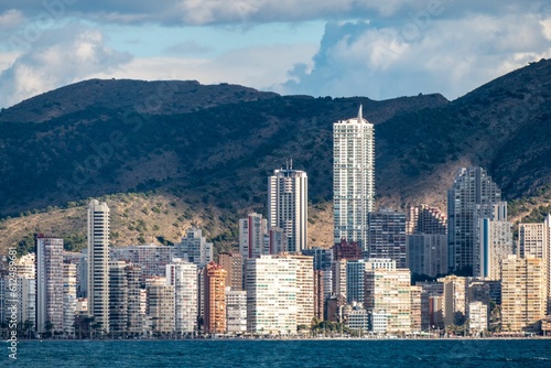 Buildings along the seashore with peaceful hills and skyline in the background, Benidorm, Spain