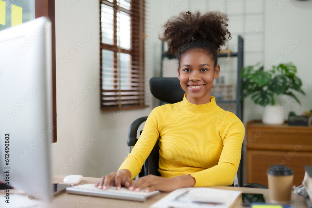 Beautiful young black woman working with laptop computer at home. Young african american female curly hair working on laptop and take note at home. Beautiful young black woman working with laptop computer at home. Young african american female curly hair working on laptop and take note at home.