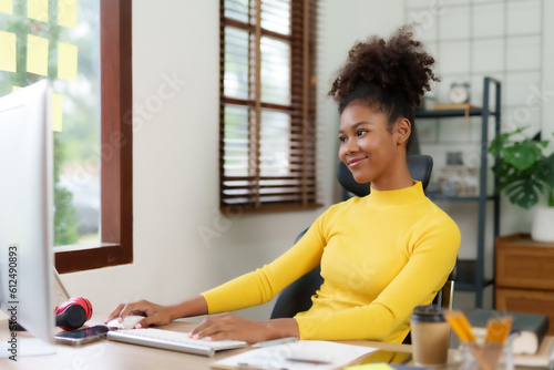 Free Download Beautiful young black woman working with laptop computer at home. Young african american female curly hair working on laptop and take note at home. - GFXLoad