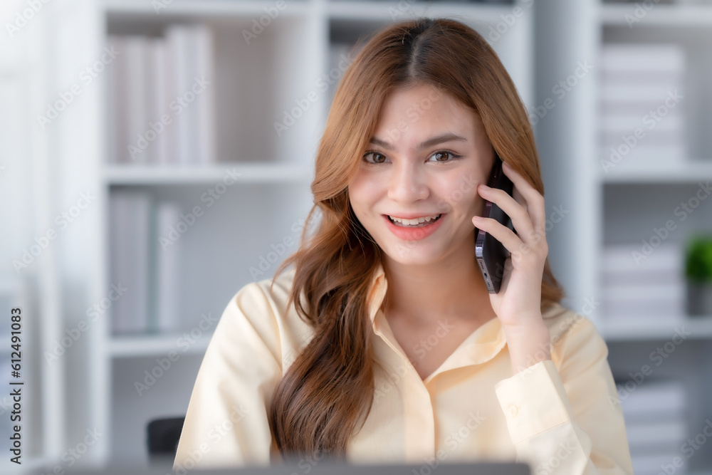 Happy beautiful smiling businesswoman talking on mobile phone whith laptop working in office. Happy beautiful smiling businesswoman talking on mobile phone whith laptop working in office.