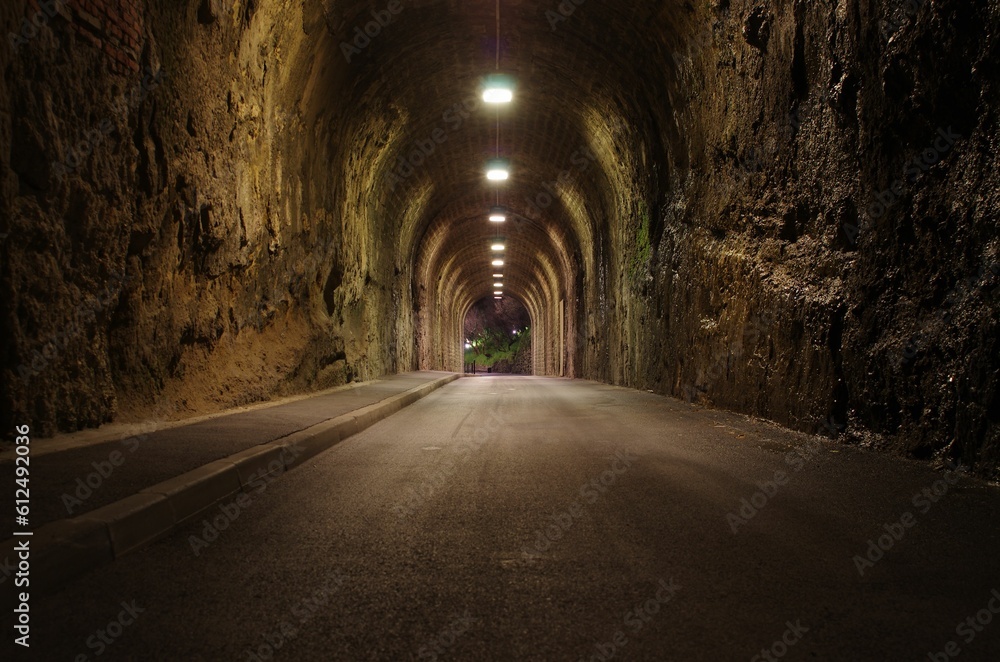 Empty arched road tunnel with lighting