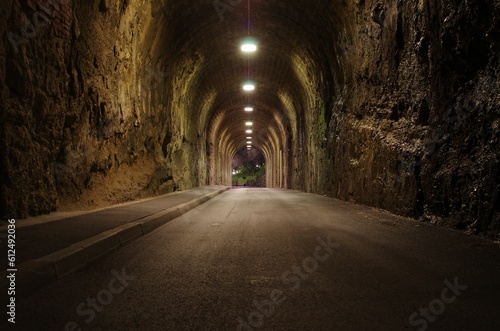 Empty arched road tunnel with lighting