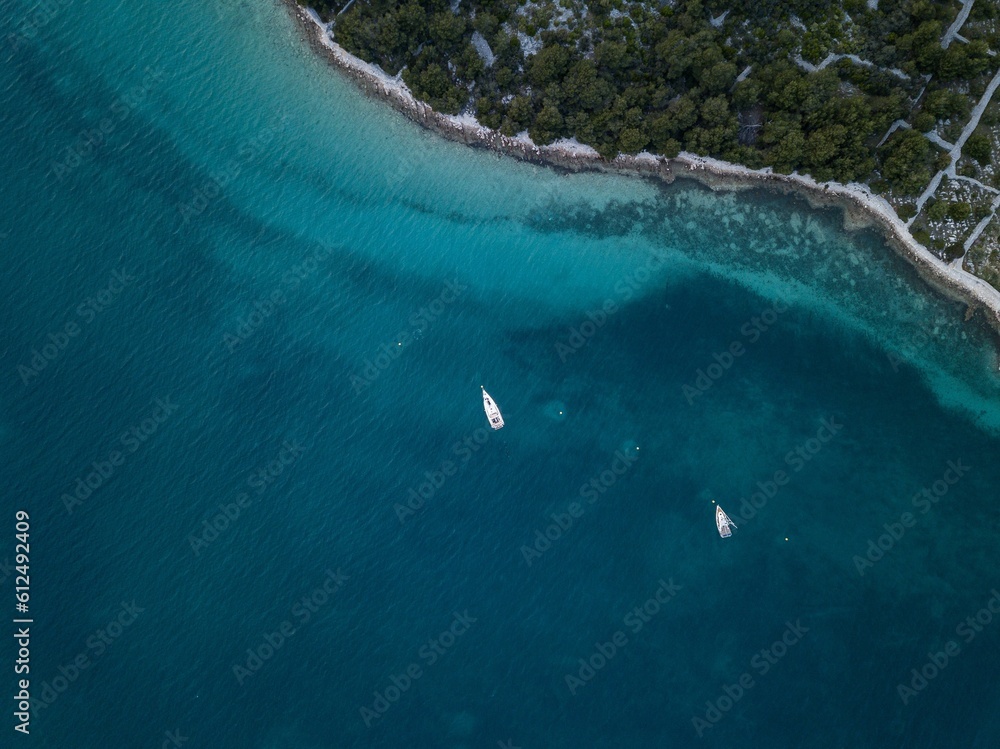 Top view of a white yacht sailing in the sea on a sunny day