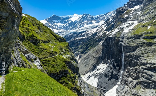 Rugged mountain peaks of Grindelwald with some of the heights covered in snow and some grass