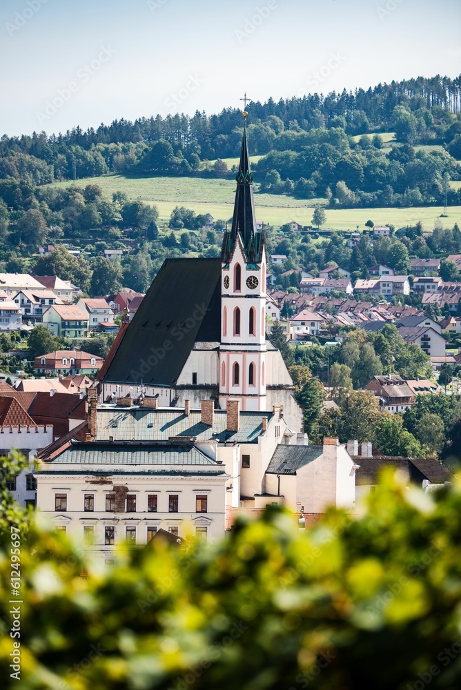 Vertical drone shot of the Church of St. Vitus surrounded by hills in Cesky Krumlov, Czechia