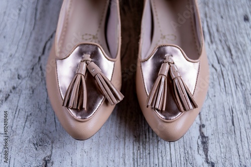 Closeup shot of women's cream flat shoes, ballet flats on a wooden background