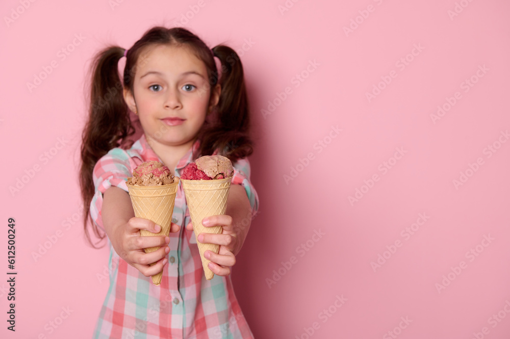 Detail on waffle cones with delicious ice cream in the hands of a cute baby girl, holding out at camera refreshing sweet frozen dessert, isolated on pink background with copy ad space. Summer concept Detail on waffle cones with delicious ice cream in the hands of a cute baby girl, holding out at camera refreshing sweet frozen dessert, isolated on pink background with copy ad space. Summer concept