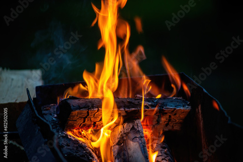 Burning wood and paper. Firewood is burning. Tongues of flame. Orange flame bonfire. Of-fire cooking,  firewood is burning for cooking barbecue