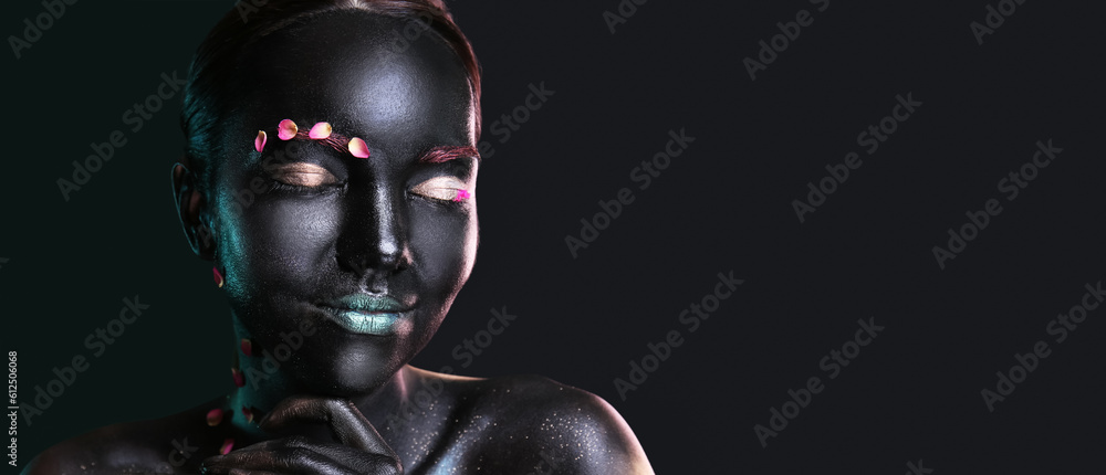 Beautiful woman with black paint on her body against dark background with space for text Beautiful woman with black paint on her body against dark background with space for text