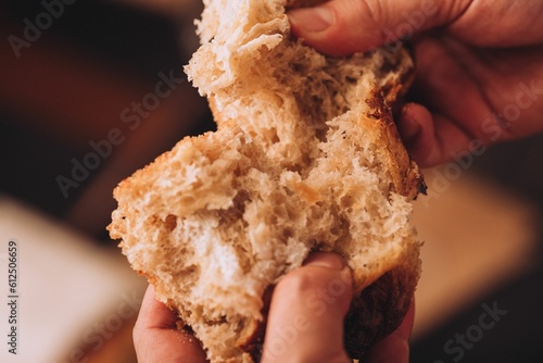 Cuadro en lienzo Closeup of a man tearing the freshly baked Italian bread on the blurred backgrou