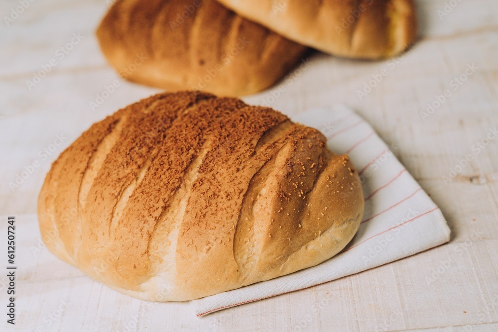 High angle of freshly baked crusty bread put on the white table surface