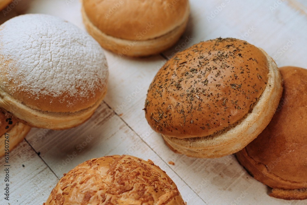 High angle of the freshly baked bun breads put on the white table surface High angle of the freshly baked bun breads put on the white table surface