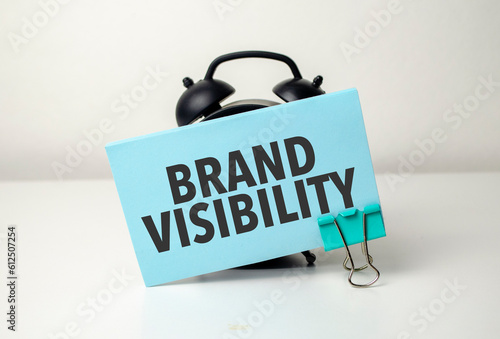 brand visibility is written in a blue sticker near a black alarm clock