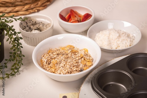 Table with bowls filled with cereals and strawberries for cooking cookies