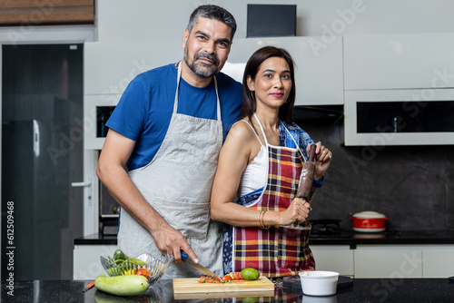 Portraits of indian couple standing in kitchen