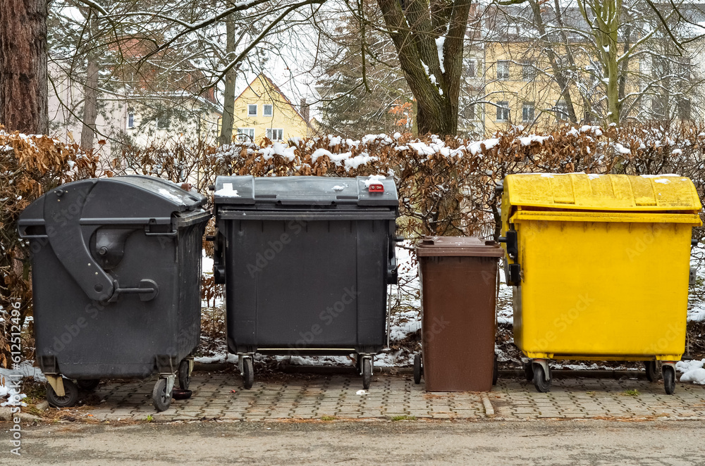View of garbage containers in city on winter day View of garbage containers in city on winter day