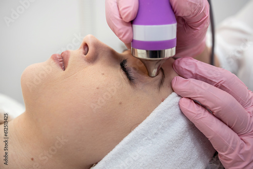 Cosmetologist doing ultrasound skin on face tightening for rejuvenation at spa