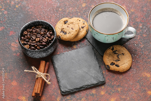 Drink coasters with cup of coffee, cookies and cinnamon on brown grunge table
