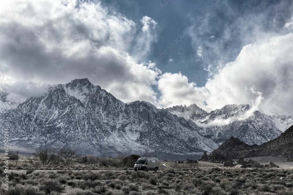 Empty off-road vehicle in front of a picturesque mountain landscape blanketed in fresh snow