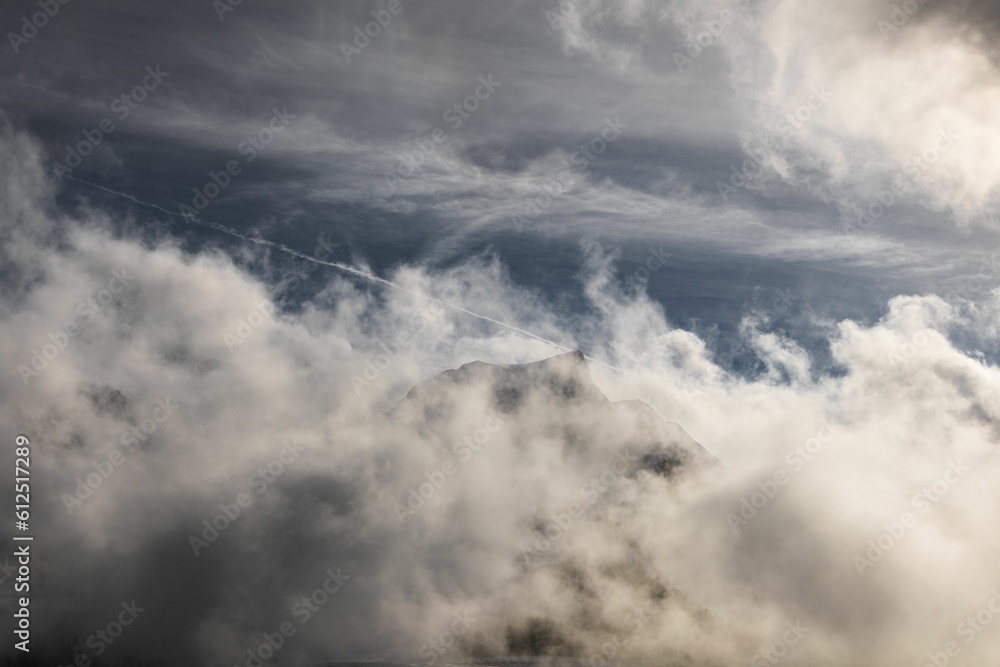 Fototapeta premium Dramatic ambiance of white clouds over the Gantrisch Mountain in Swiss Alps