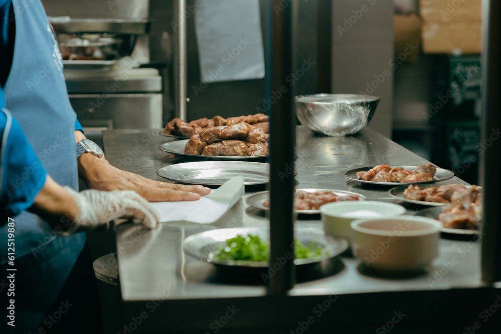 View through a window of a chef preparing a meal with meat