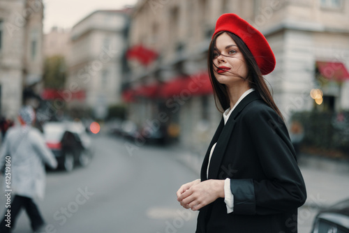 Fashion woman portrait standing on the street in front of the city in stylish clothes with red lips and red beret, travel, cinematic color, retro vintage style, urban fashion lifestyle.