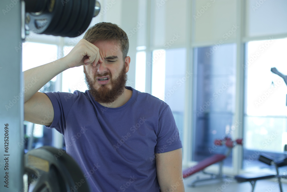 Portrait of tired exhausted sad man unhappy guy in the gym, feeling bad during training Portrait of tired exhausted sad man unhappy guy in the gym, feeling bad during training