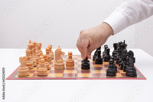 The chess player's hand moves a black pawn.