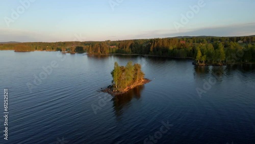 Slow-motion drone footage of a small green-covered isleon a lake in Delsbo, Halsingland, Sweden photo