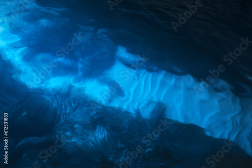 Blurred blue underwater view with white sand on a seabed © evannovostro