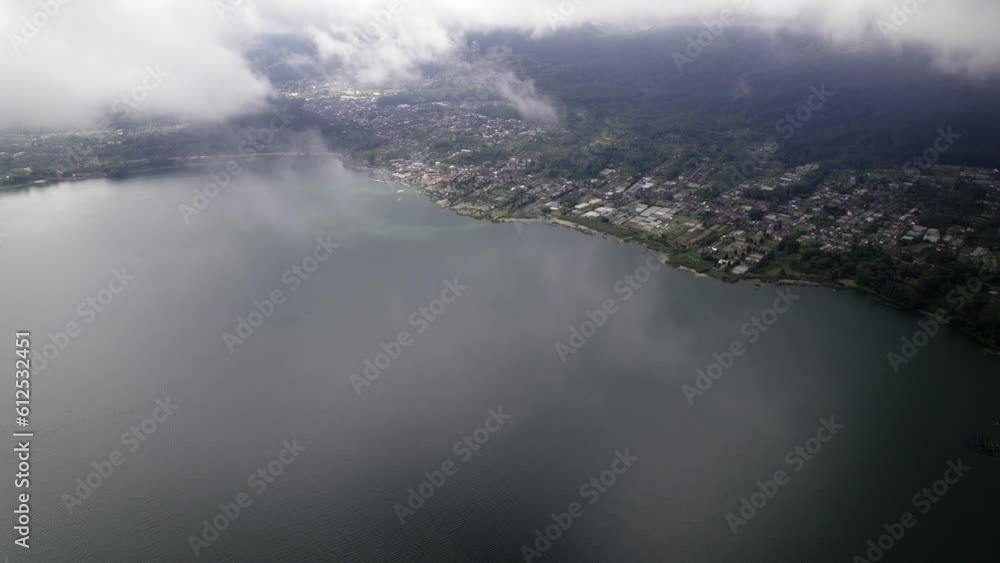Drone view over clouds and a town on a waterfront Drone view over clouds and a town on a waterfront
