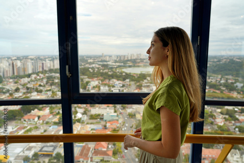 Young woman enjoying cityscape on the panoramic tower of Curitiba, Parana, Brazil photo