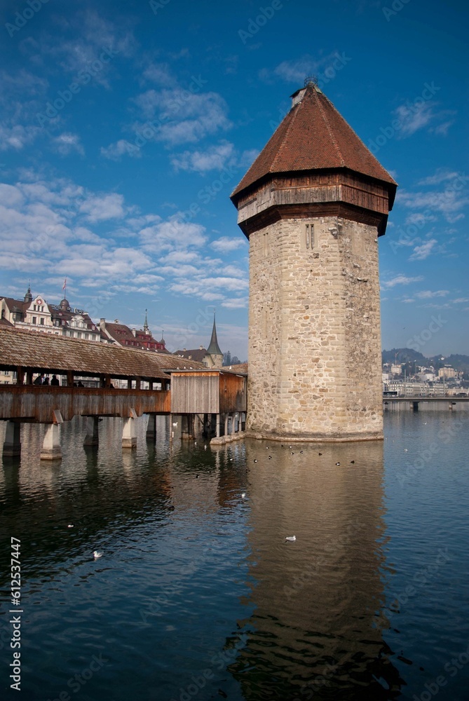 Vertical shot of the Chapel bridge and the tower of Lucerne in Switzerland over the calm Reuss river