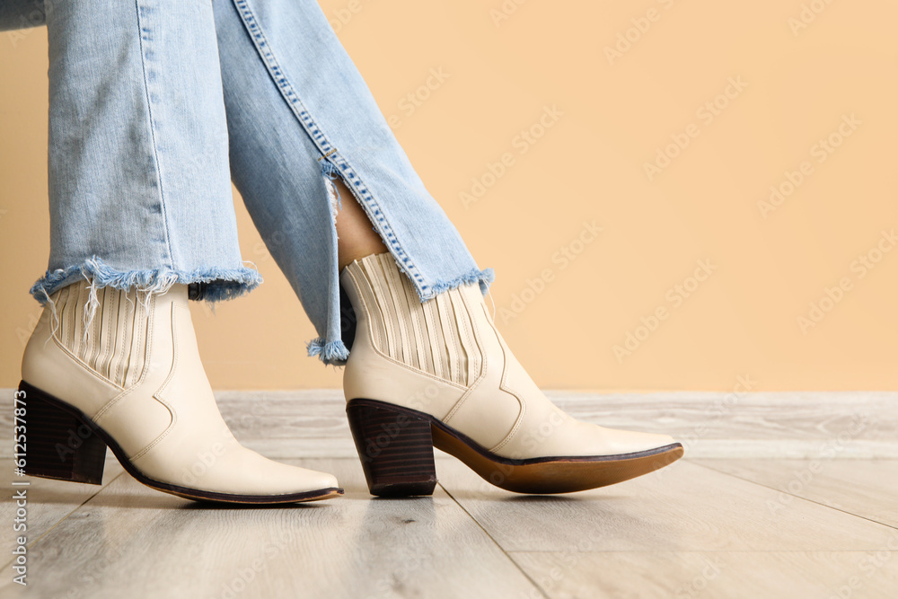 Female legs in stylish shoes near color wall, closeup Female legs in stylish shoes near color wall, closeup