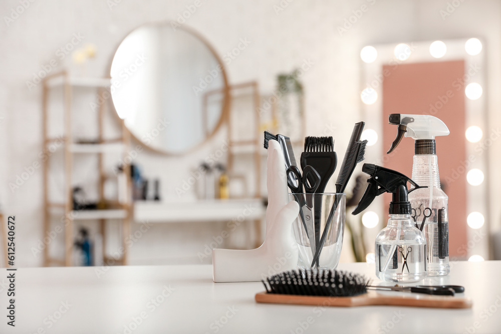Different hairdressing tools on table in beauty salon - obrazy, fototapety, plakaty 