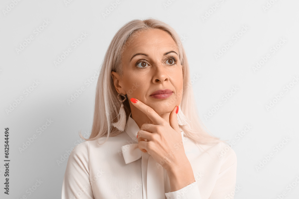 Mature blonde woman on light background, closeup Mature blonde woman on light background, closeup