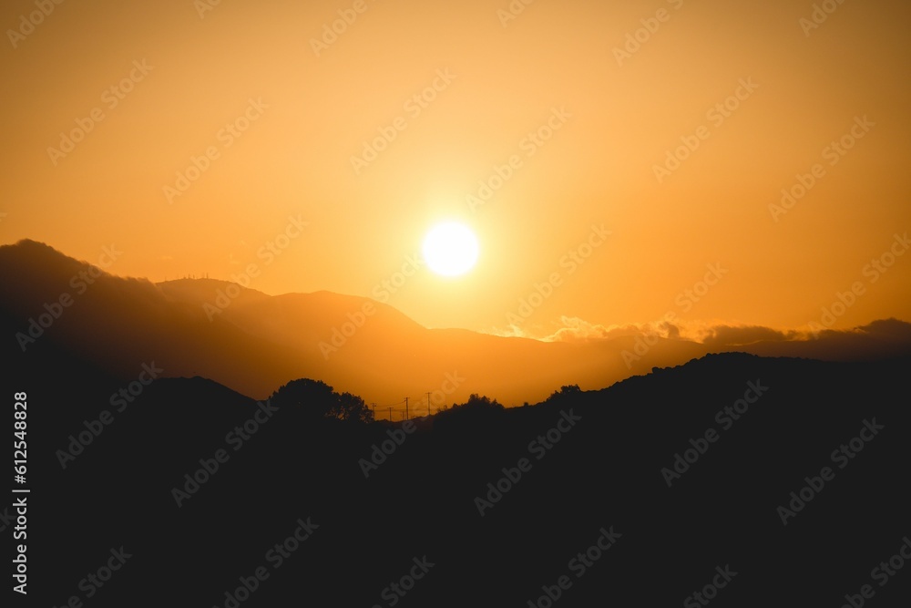 Silhouette of hills at bright orange sunset