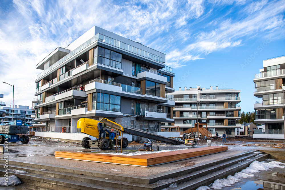 construction of houses, a shopping center from concrete blocks in the city. construction of a new residential quarter in winter. construction yellow equipment erects a quarter