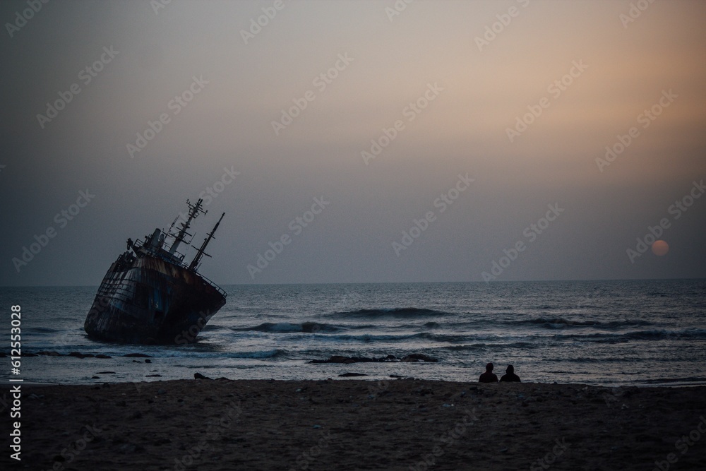 Beautiful shot of a historic dirty old ship after a shipwreck on a seashore at sunset