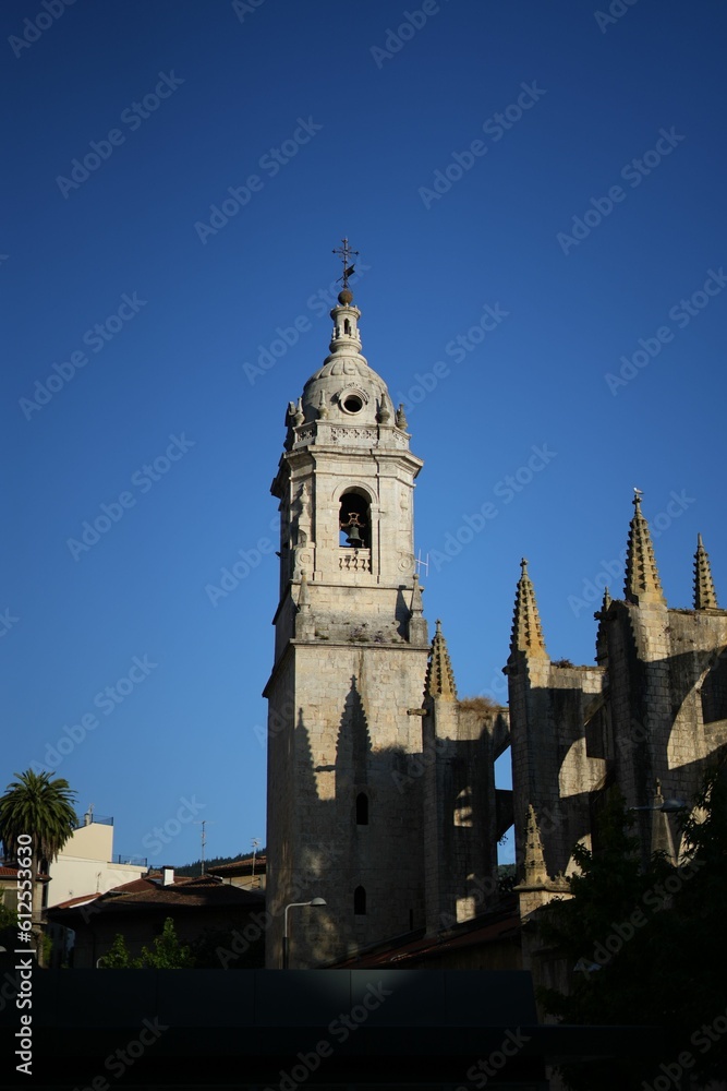 Vertical shot of a cathedral under a clear blue sky in Lekeitio, Spain