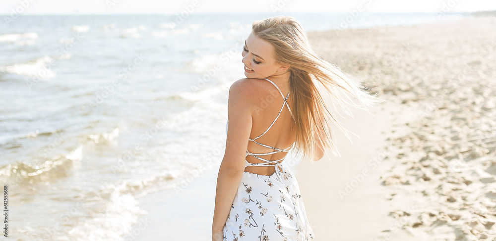 Happy blonde woman in free happiness bliss on ocean beach standing straight and posing. Happy blonde woman in free happiness bliss on ocean beach standing straight and posing.