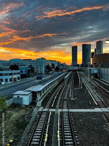 Vertical shot of a sunset over the railroad and buildings.
