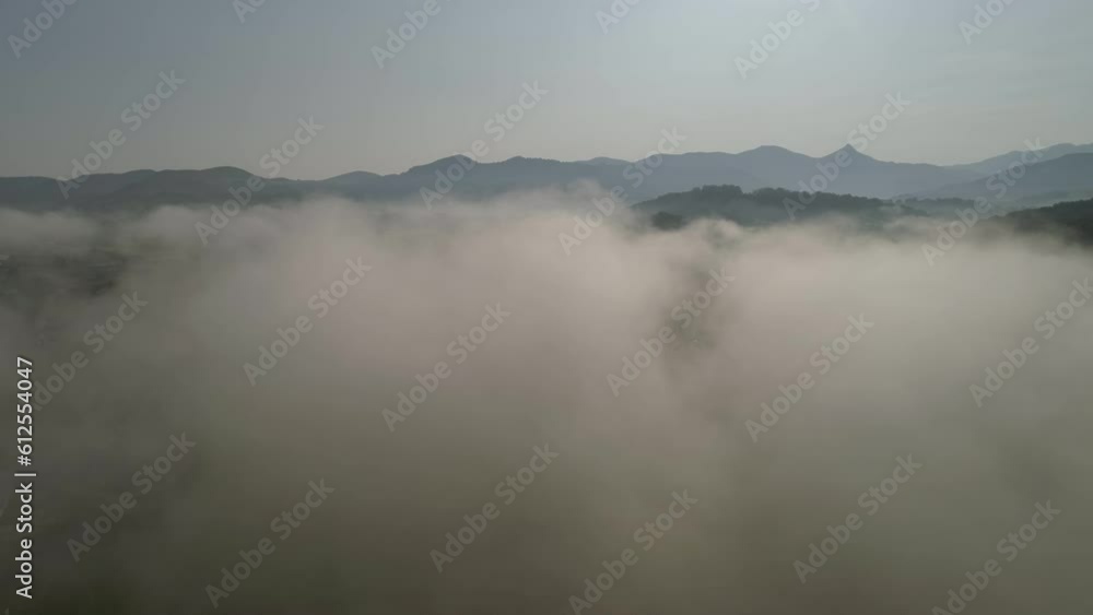 High-angle view of the green landscape through the clouds in Pays Basque, France. High-angle view of the green landscape through the clouds in Pays Basque, France.