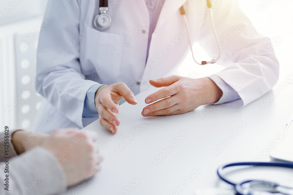 Doctor and patient discussing current health questions while sitting at the table in clinic office, only hands closeup. Medicine concept. Doctor and patient discussing current health questions while sitting at the table in clinic office, only hands closeup. Medicine concept.