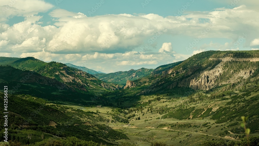 Aerial view of a mountainous green landscape with lush nature in cloudy sky background