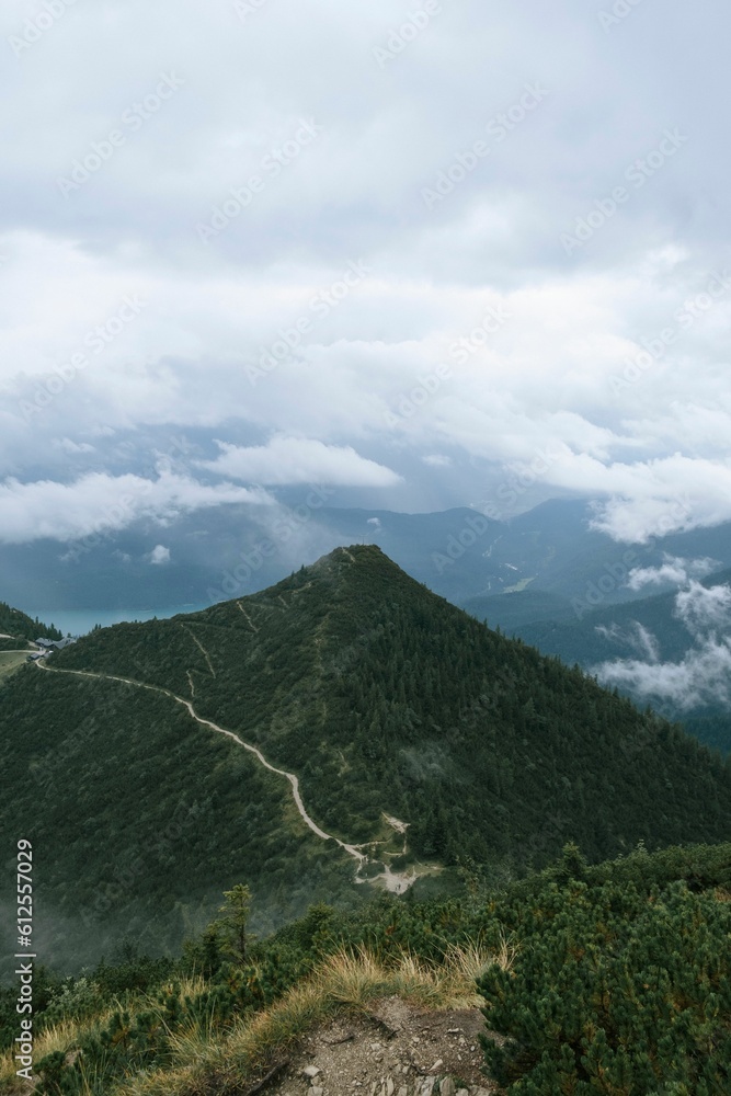 Aerial vertical view of the white clouds touching green mountains with lush green vegetation Aerial vertical view of the white clouds touching green mountains with lush green vegetation