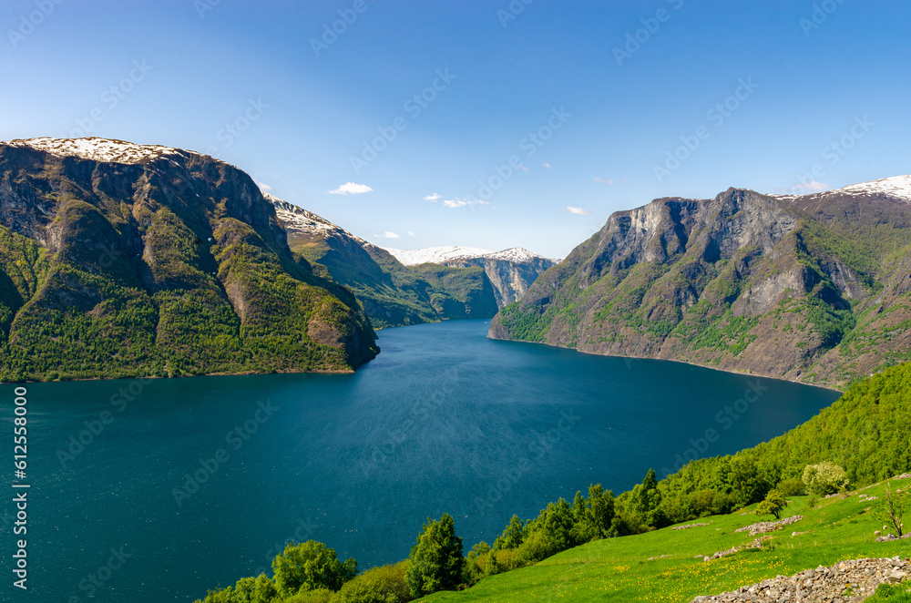 Beautiful view of Norwegian mountains on a clear sunny day with fjordfull of fish. Super green scenery idyllic nature just like a postcard.